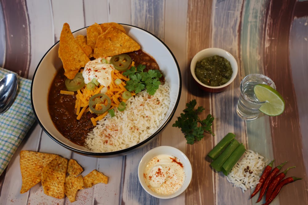 Mexicaans geinspireerde bowl met rijst, chili, nachos en verse kruiden